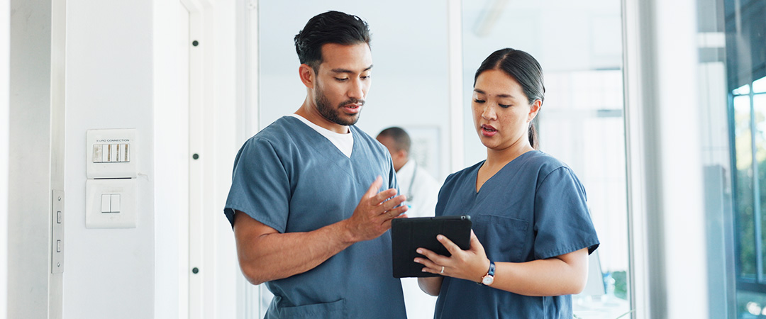 yolo-1080x450-99 two lab technicians looking at a tablet computer analyzing results.